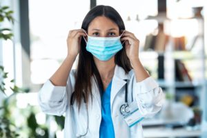 female doctor wearing hygienic face surgical medical mask to prevent infection,